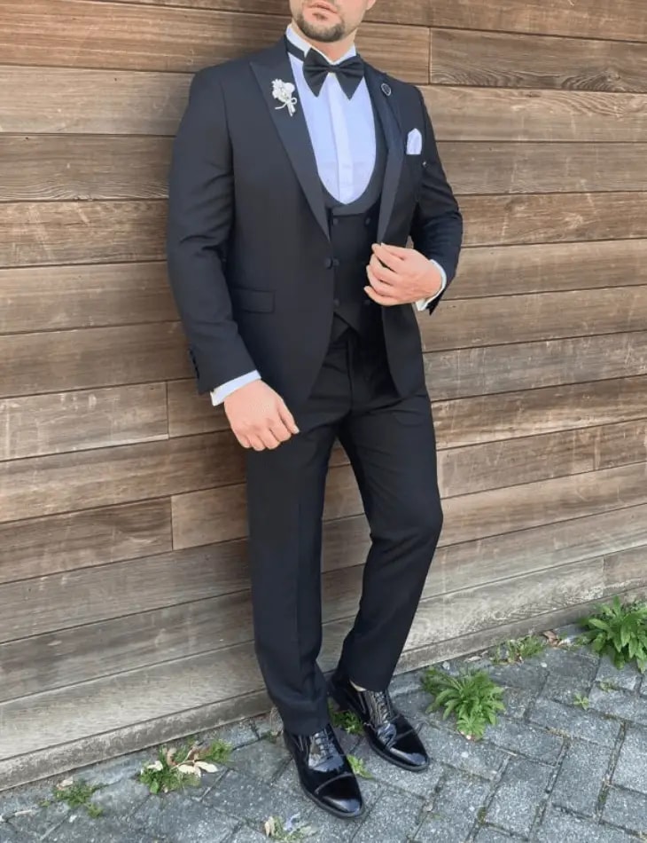 Stijlvolle man in zwart kostuum met vlinderdas