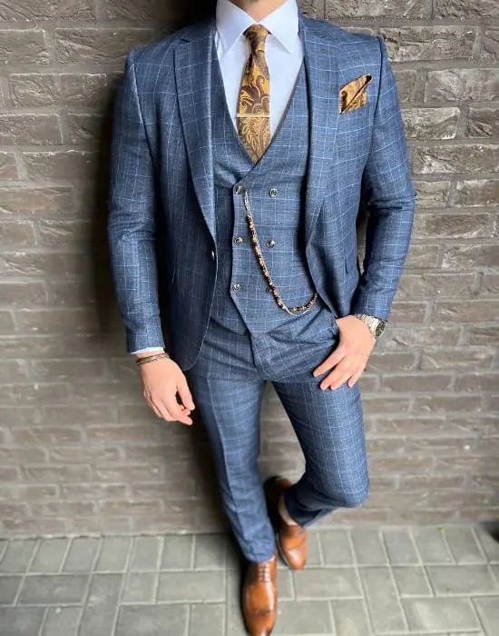 Homme en costume bleu à carreaux avec cravate dorée