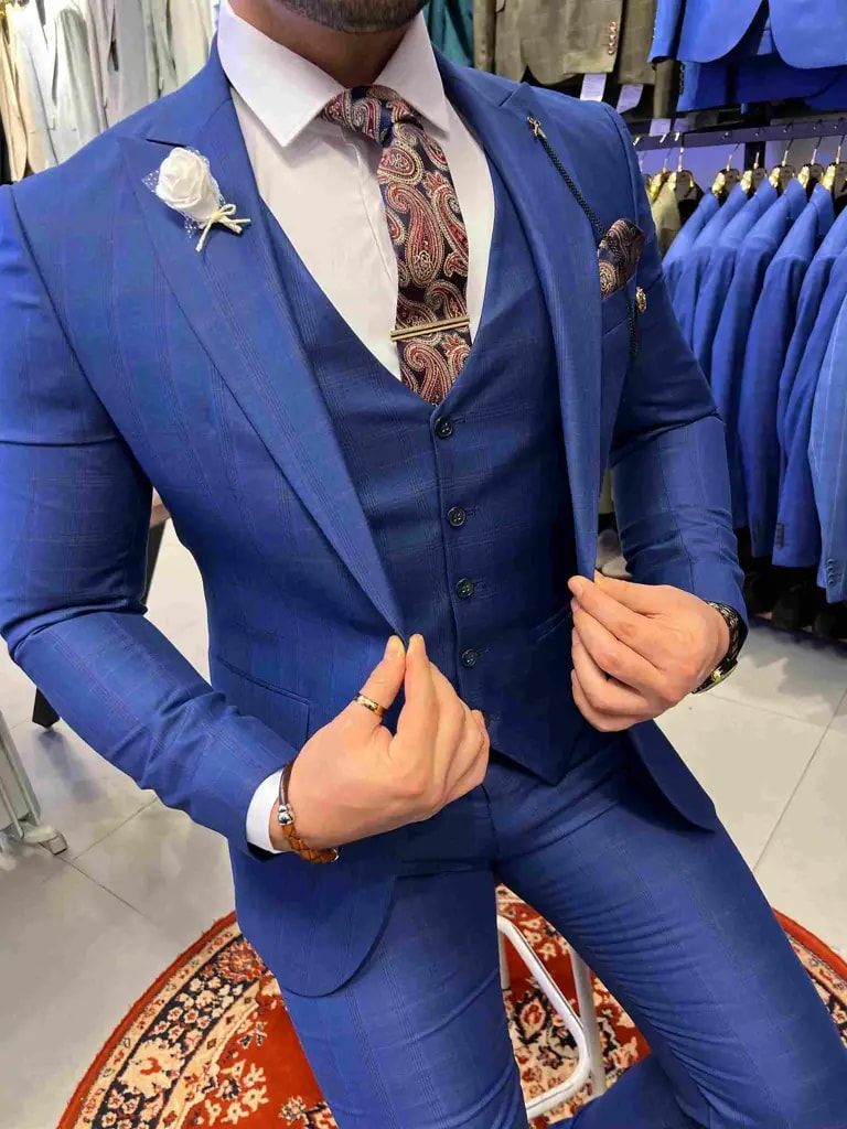 Homme portant un costume bleu élégant avec cravate à motifs.
