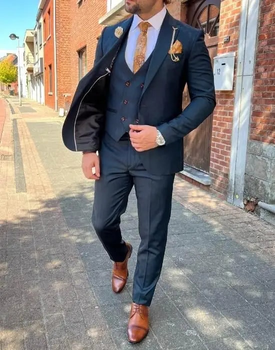 Homme en costume élégant bleu marine avec accessoires