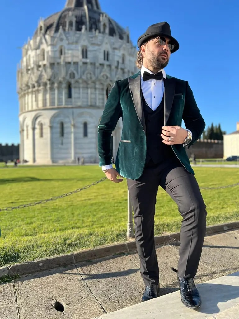 Homme élégant en costume vert devant un monument historique