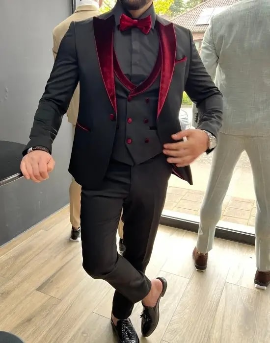 Costume élégant noir avec détails bordeaux, homme debout