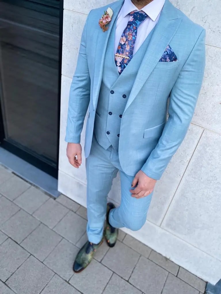 Homme en costume bleu clair avec cravate florale