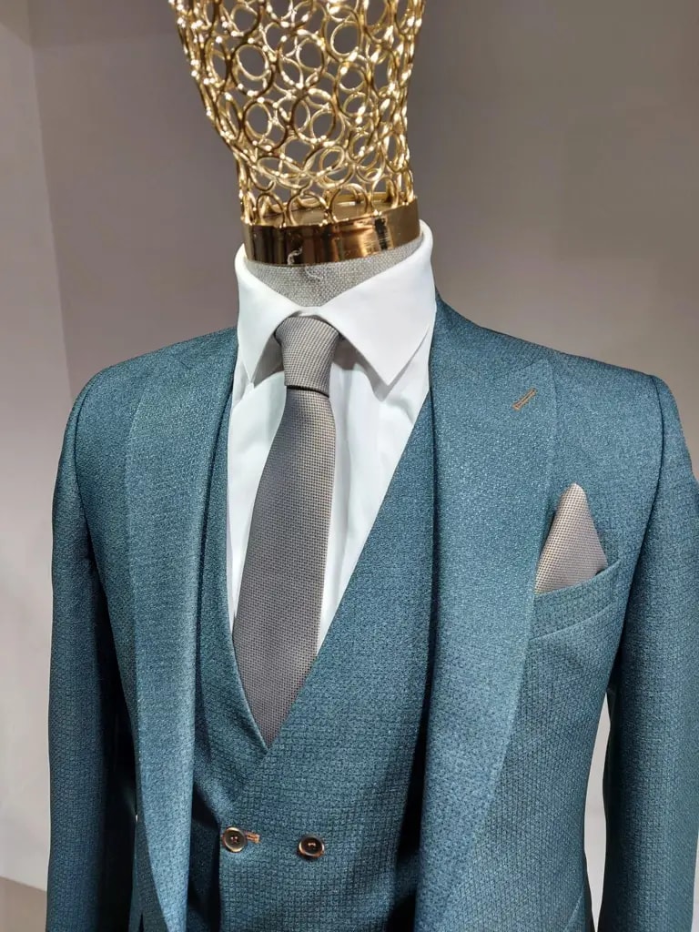 Costume élégant bleu avec cravate grise sur mannequin.