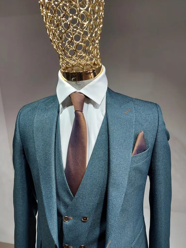 Stijlvol driedelig blauw pak met witte overhemd en bruine stropdas