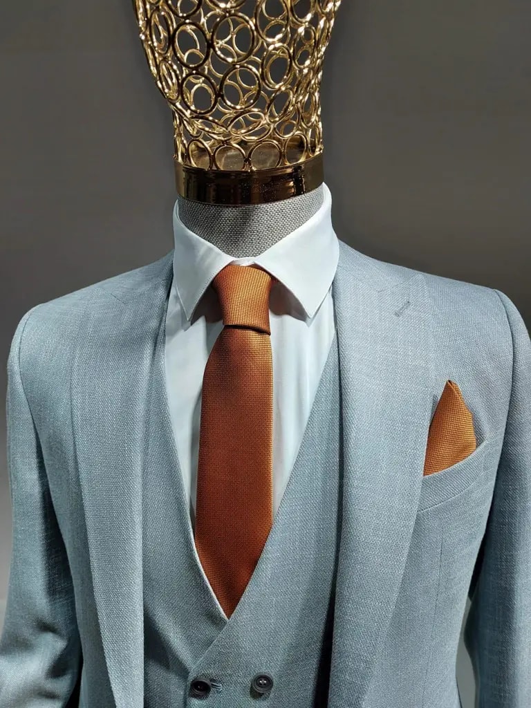 Costume trois pièces gris clair avec cravate orange