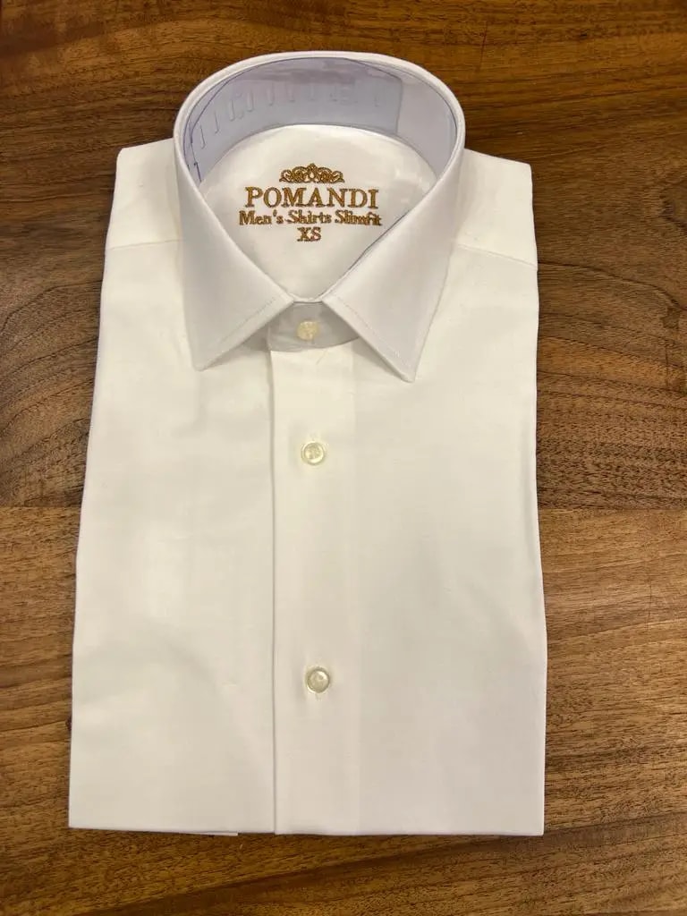 Chemise blanche élégante pliée sur une table en bois